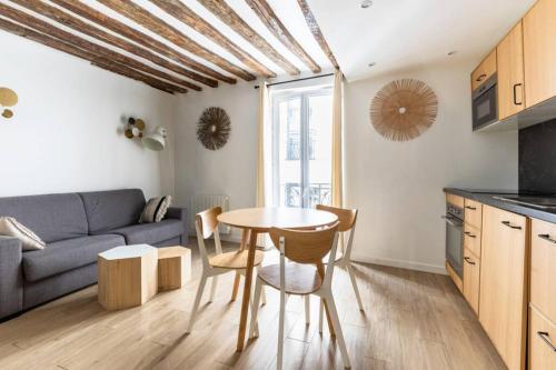 une cuisine et un salon avec une table et des chaises dans l'établissement Appartement Grands Boulevards - 21 -, à Paris