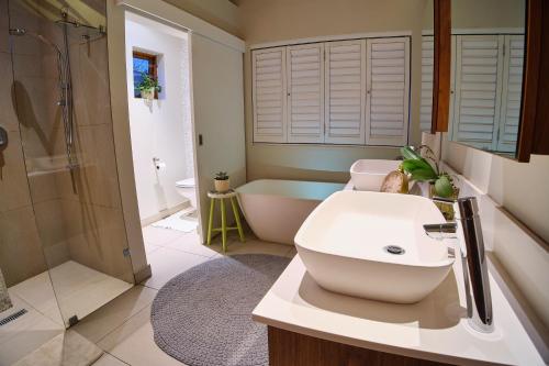 uma casa de banho com um lavatório, uma banheira e um WC. em The Cottage Farm em Stellenbosch
