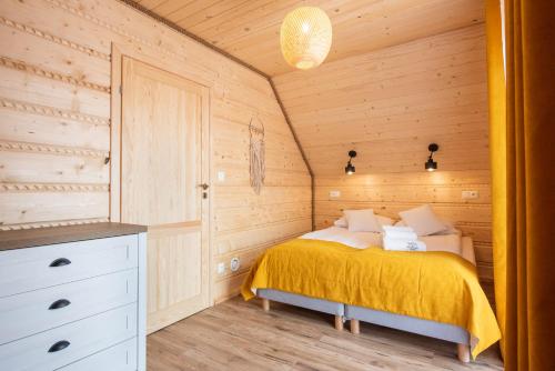 een slaapkamer met een bed in een houten hut bij Pod Brzozka in Cisna