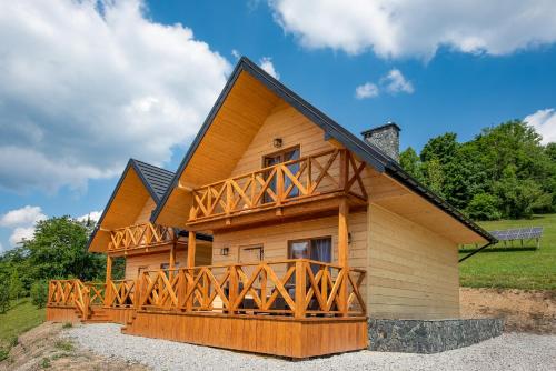 a log cabin with a large wooden deck at Pod Brzozka in Cisna