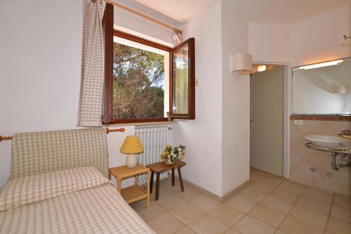 ein Schlafzimmer mit einem Bett, einem Waschbecken und einem Fenster in der Unterkunft Casa Giannellina in Orbetello