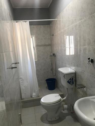 a bathroom with a toilet and a shower and a sink at BLUE RESIDENCE 