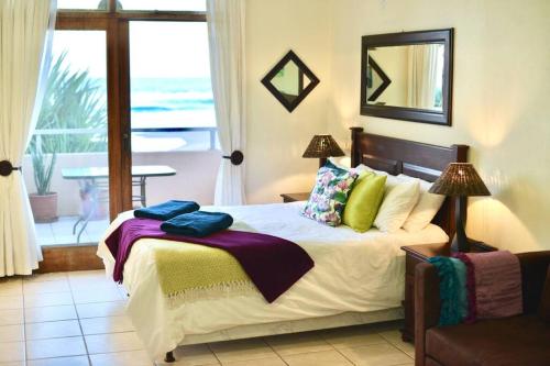 a bedroom with a bed with a view of the ocean at Ocean's 25 in Kingsburgh
