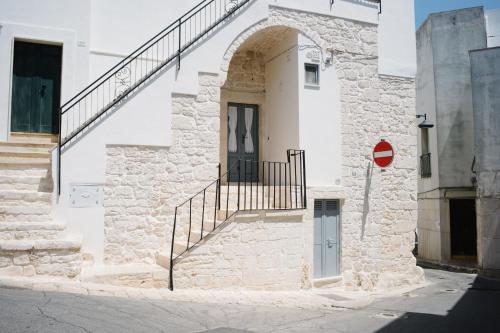 a white building with a door and stairs on it at Casa Sotto l'Arco in Ceglie Messapica