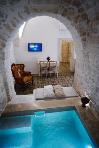 a room with a swimming pool in a stone building at Casa Sotto l'Arco in Ceglie Messapica