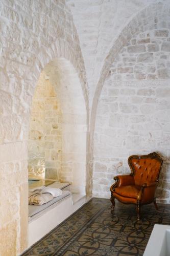 a room with a chair and a bed in a wall at Casa Sotto l'Arco in Ceglie Messapica