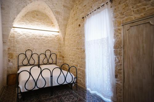 a bedroom with a bed and a large window at Casa Sotto l'Arco in Ceglie Messapica