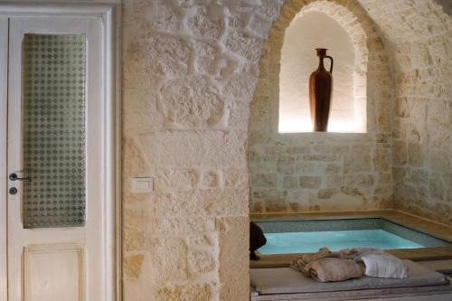a bath tub with a window and a vase at Casa Sotto l'Arco in Ceglie Messapica