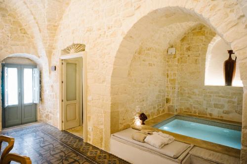 een grote badkamer met een hot tub in een stenen muur bij Casa Sotto l'Arco in Ceglie Messapica