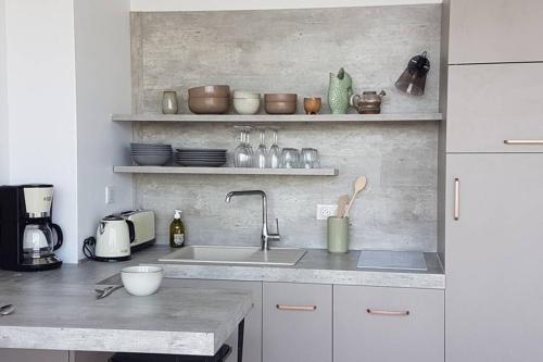 une cuisine avec un évier et un plan de travail dans l'établissement La Cabane des Dunes à Fort-Mahon Plage, à Fort-Mahon-Plage