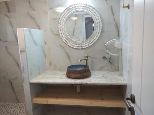 a bathroom with a sink and a mirror at Paliokaliva Home in Roussopoúlion