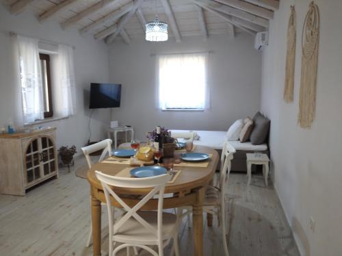 a living room with a wooden table and a couch at Paliokaliva Home in Roussopoúlion