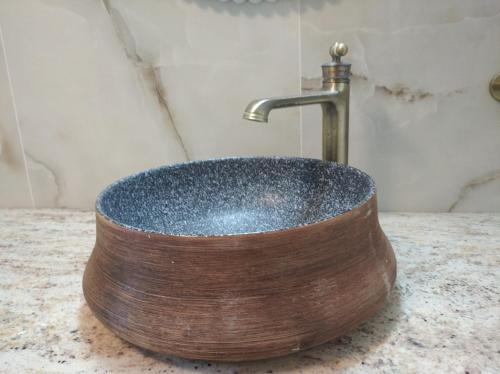 a wooden sink with a faucet on a counter at Paliokaliva Home in Roussopoúlion
