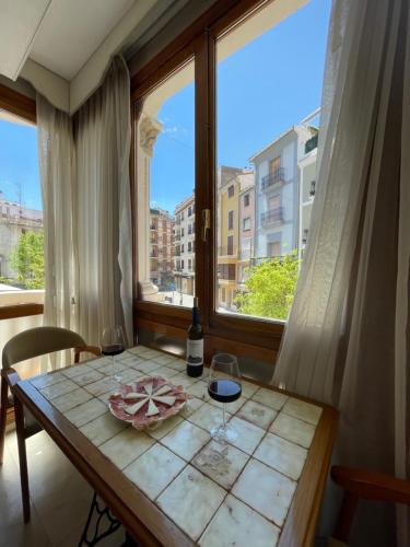 a table with two glasses of wine and a window at Varone in Requena