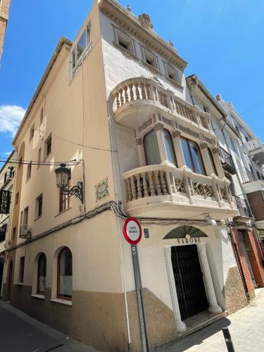 a white building with a balcony on a street at Varone in Requena