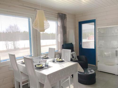 a dining room with a white table and chairs at Lapland Happiness Hillakka 2 a8 in Äkäslompolo