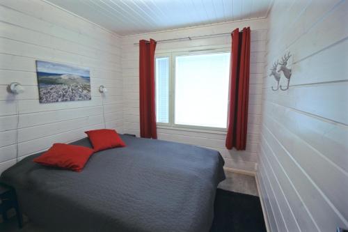 アカスロンポロにあるLapland Happiness Hillakka 2 a8のベッドルーム1室(赤いカーテンと窓付きのベッド1台付)