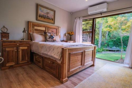 Un dormitorio con una cama grande y una ventana grande. en Home in Cape Town-The Homestead, en Stellenbosch