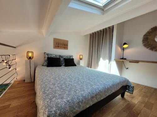 ein Schlafzimmer mit einem Bett mit blauer Bettdecke und einem Fenster in der Unterkunft Duplex BULLES D'AIX terrasse centre historique in Aix-en-Provence