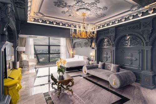 a bedroom with a bed and a couch and a chandelier at arte by Thomas Chan in Kuala Lumpur