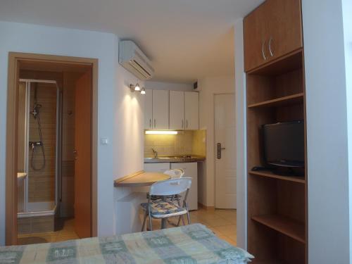 Zimmer mit einem Bett und einem Tisch sowie einer Küche in der Unterkunft Tip-Top Apartmenthouse in Balatonfüred