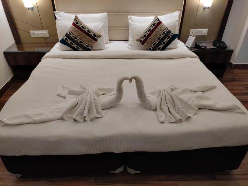 two swans made out of towels on a bed at THE DOWNTOWN in Kānpur