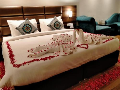 a bed with red flowers on it in a room at THE DOWNTOWN in Kānpur