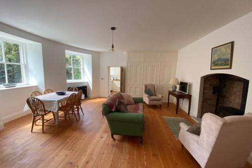 a living room with a green couch and a table at The Courtyard Apartment, Strangford in Strangford