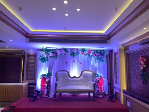 a stage with a white couch in a room at THE DOWNTOWN in Kānpur