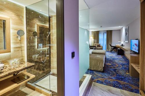 a hotel bathroom with a shower and a bedroom at A Hoteli - Hotel Park in Vrnjačka Banja