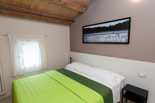 1 dormitorio con 1 cama y TV en la pared en Casa Bassetto, en Longare