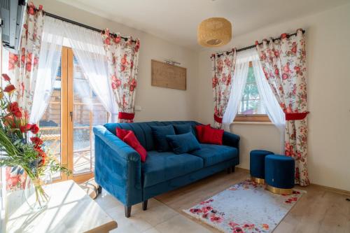 Sofá azul en la sala de estar con ventanas en Smrekowy Domek, en Kościelisko
