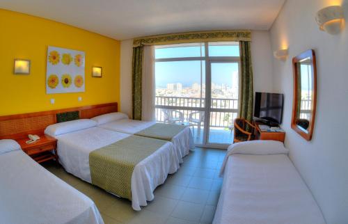 a hotel room with two beds and a balcony at Hotel & Spa Entremares in La Manga del Mar Menor