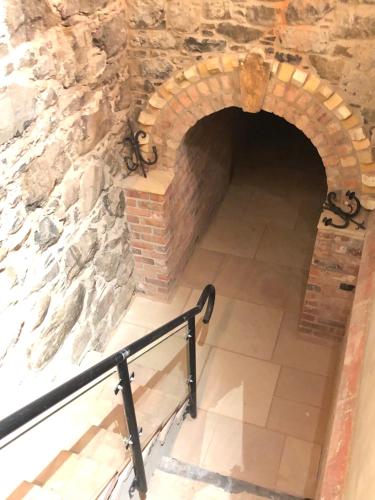 an archway in a stone wall with a railing at The Old Flax Mill Yoga Retreat in Coleraine