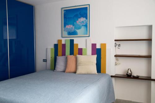 a bedroom with a bed with a colorful headboard at Maison Poppy in Aosta