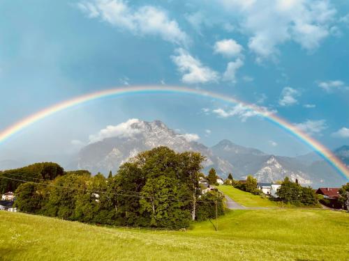 a rainbow over a field with a mountain in the background at KAINZLEITENHOF in Nachdemsee
