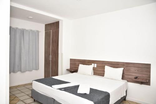 Un dormitorio con una cama grande con una cruz. en Duna´s guest house en Salvador