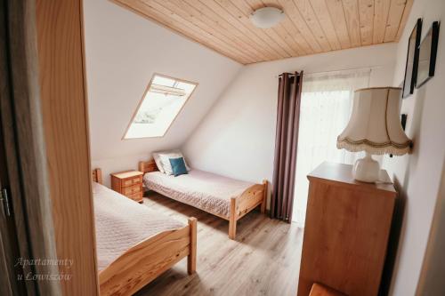 a small bedroom with two beds and a window at Apartament u Łowiszów in Witów