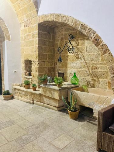 a stone wall with a fountain in a courtyard with potted plants at Nonna Veronica in Gemini