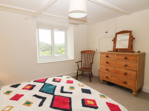 a bedroom with a bed and a dresser and a mirror at 3 West Street in Tiverton