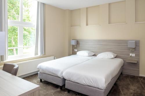 Ένα ή περισσότερα κρεβάτια σε δωμάτιο στο Fletcher Kloosterhotel Willibrordhaeghe