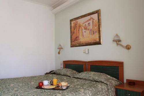 a bedroom with a bed with a tray of food on it at Hotel Platon in Athens