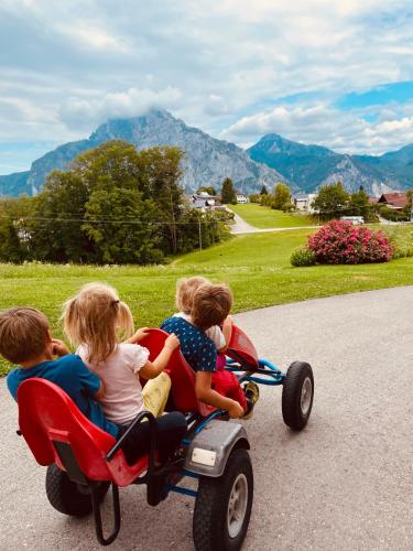 a group of children riding on a toy car at KAINZLEITENHOF in Nachdemsee