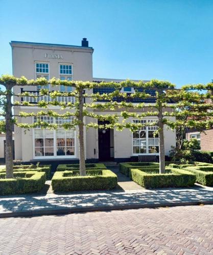 a building with trees and bushes in front of it at Boukje har Bêd en Brochje in Bergum