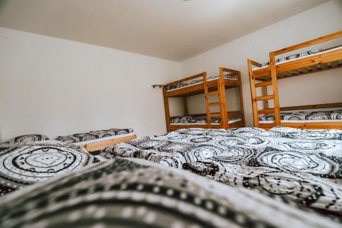 two beds in a room with two bunk beds at Chaty a Apartmány Hracholusky Kemp Kosatka in Pňovany