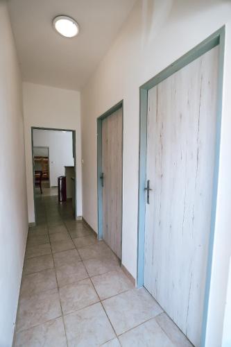 an empty hallway with two doors and a tile floor at Chaty a Apartmány Hracholusky Kemp Kosatka in Pňovany
