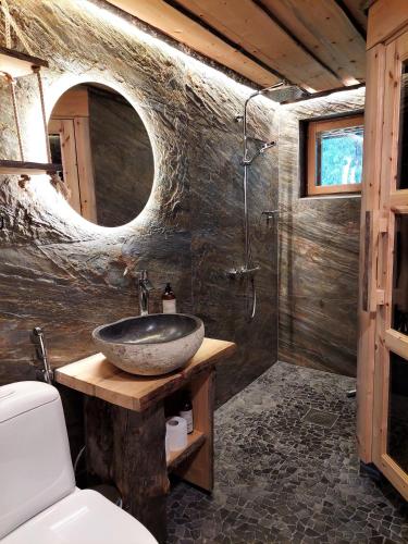 a bathroom with a stone sink and a shower at Isokelo Log Apartments in Salla