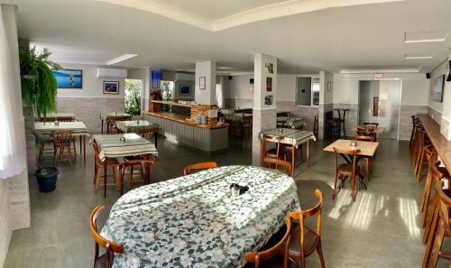 un restaurante con mesa, sillas y barra en Hotel Pontal, en Palhoça