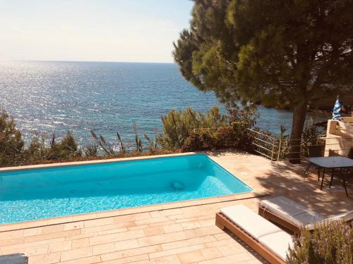 a swimming pool with a view of the ocean at VILLAPARADISO Beach front Villa Makris Gialos in Argostoli
