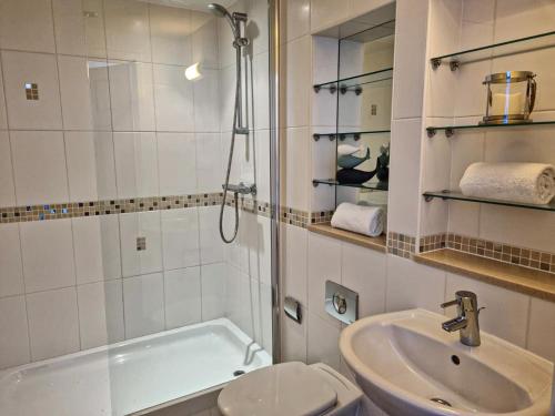 a bathroom with a sink and a toilet and a shower at Harbourside Apartments in Portpatrick